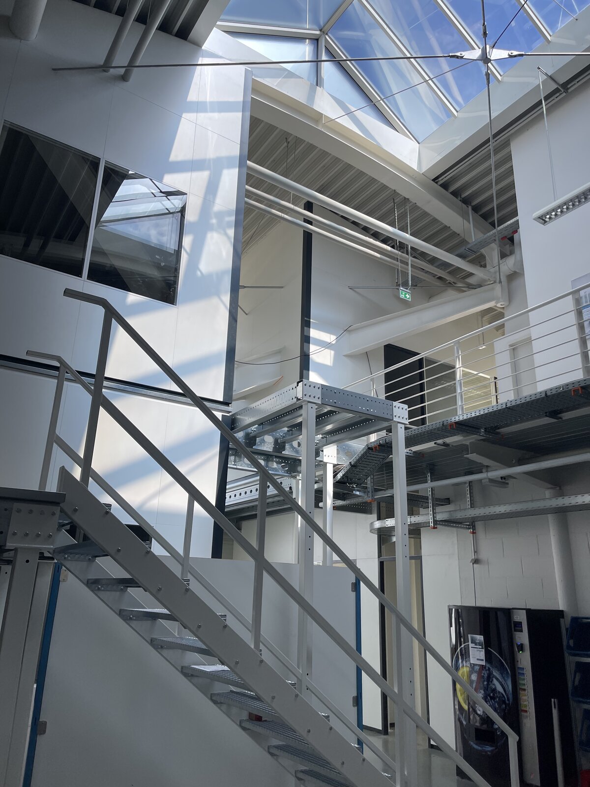 Industrielle Mezzanin-Konstruktion mit Glasdach und Stahltreppe